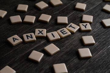 Anxiety. Flat lay photography - Word/s made with lettered tiles on timber background.