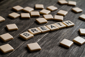 Breath. Flat lay photography - Word/s made with lettered tiles on timber background.