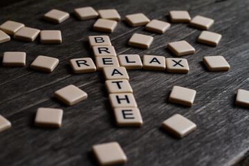 Relax Breathe. Flat lay photography - Word/s made with lettered tiles on timber background.