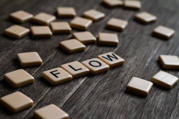 Flow Text. Flat lay photography - Word/s made with lettered tiles on timber background.