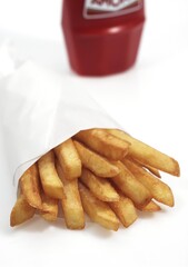 FRENCH FRIES WITH KETCHUP AGAINST WHITE BACKGROUND