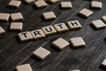 Truth Text. Flat lay photography - Word/s made with lettered tiles on timber background.