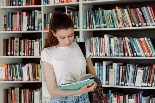 Female student reading book in library
