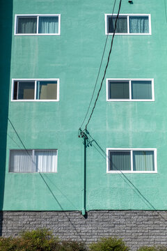 A mint colored apartment building in the sun