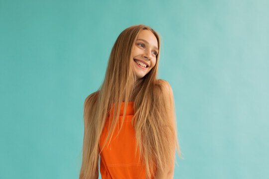 Content teen blonde smiling on turquoise background