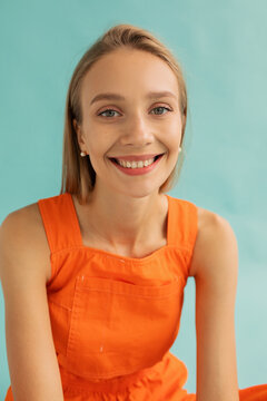 Content teen blonde smiling on turquoise background