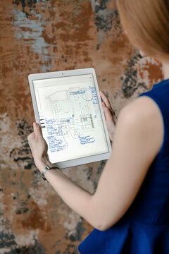 Female engineer holding tablet with map of building.