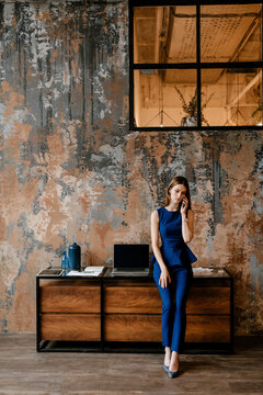 Female designer talking to call phone on workplace.