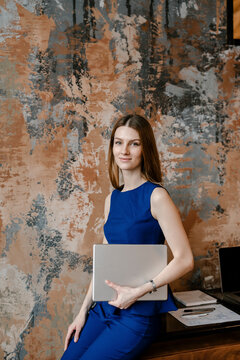 Pretty female engineer sitting on table with tablet in hand.