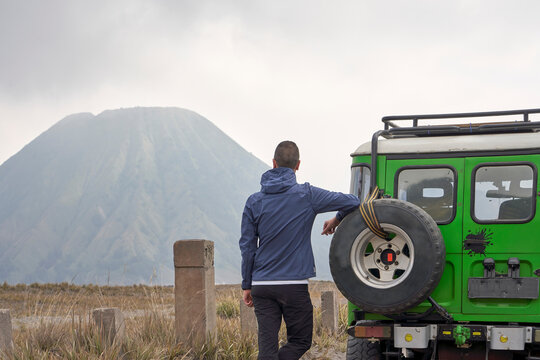 Man visiting Bromo volcano and Leaning To a jeep