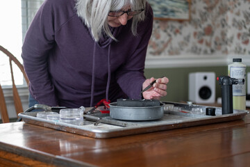 Woman making jewelry pendent