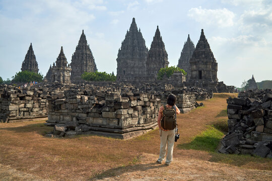 Back view of woman with backpack looking at Prambanan Temple, Java, Indonesia