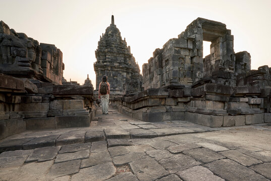 Back view of woman with backpack looking at a stupa in Prambanan Temple, Java, Indonesia