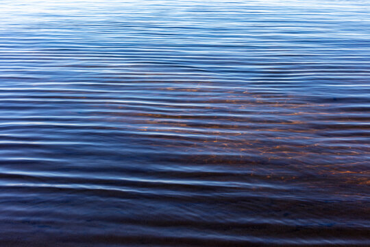 Small waves on surface of clear lake water