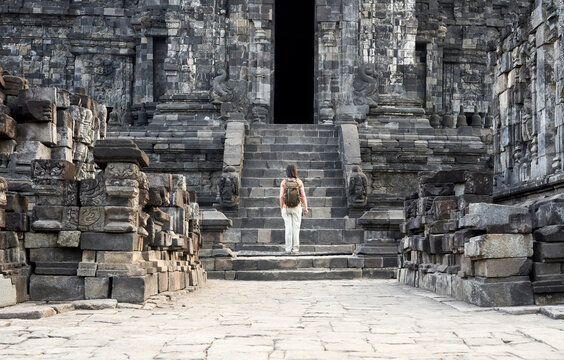 Woman with backpack standing in front of the gate in Prambanan Temple, Java, Indonesia.