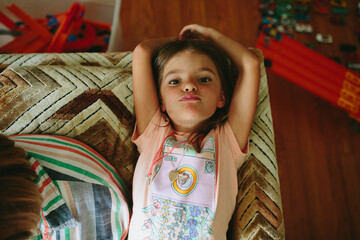 girl makes silly faces on couch