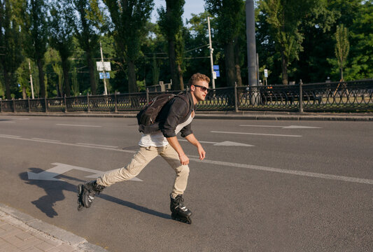 a roller skater rides fast at sunset with a rucksack on his back