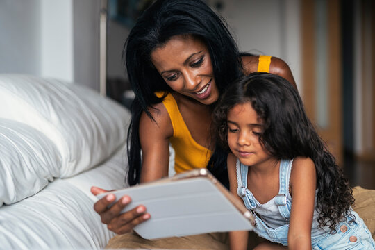 Mother and daughter using device at home