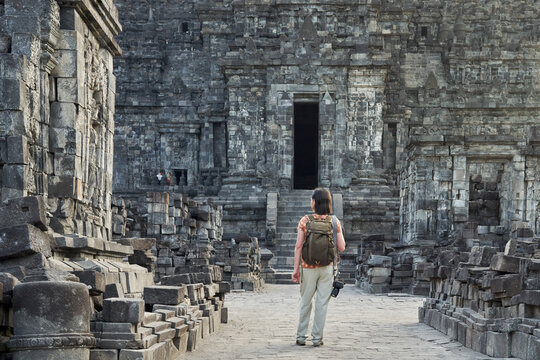 Woman with backpack standing in front of the gate in Prambanan Temple, Java, Indonesia.