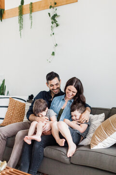Young Family Laughing Together in Modern Home