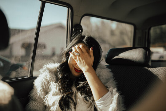 fun lifestyle portrait of Asian woman sitting in a car
