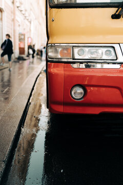 Part of red and yellow bus.Rainy day.