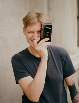 Man taking photo with point-and-shoot camera