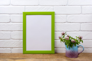 Green poster frame mockup with pink clover in pitcher