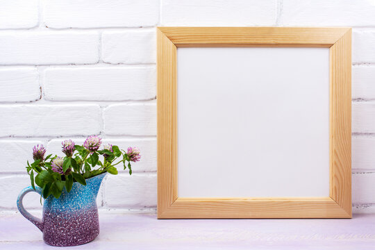Wooden square picture frame mockup with pink clover