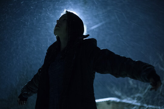 a girl in a warm coat enjoys the snowfall