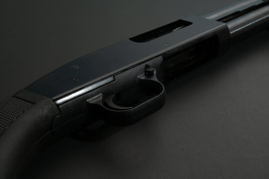 Close up of a 12 gauge shotgun on black background.