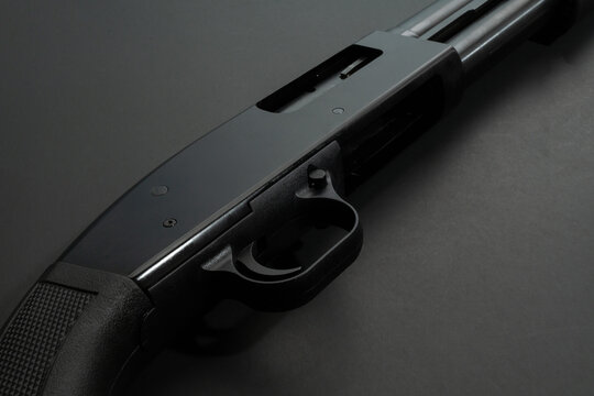 Close up of a 12 gauge shotgun on black background.