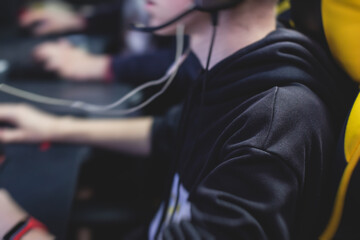 Cyber sport e-sports tournament, team of professional gamers, close-up on gamer's hands on a keyboard, pushing button, gamers playing in competitive moba/strategy fps game on a cyber games arena club