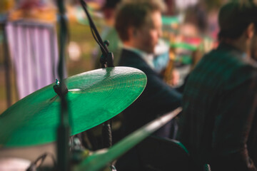 Drummer percussionist performing on a stage with drum set kit during jazz rock show performance,...