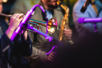 Concert view of a male trumpeter, professional trumpet player with vocalist and musical during jazz band performing