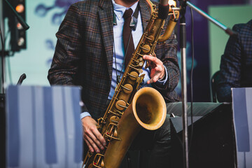 Concert view of a saxophonist, saxophone player with vocalist and musical during jazz orchestra...
