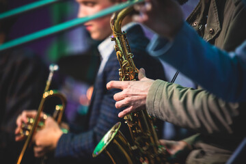 Fototapeta premium Concert view of a saxophonist, saxophone player with vocalist and musical during jazz orchestra performing music on stage
