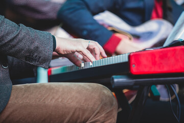 Fototapeta premium Concert view of a musical keyboard piano player during musical jazz band orchestra performing, keyboardist hands during concert, male pianist on stage, hands close up
