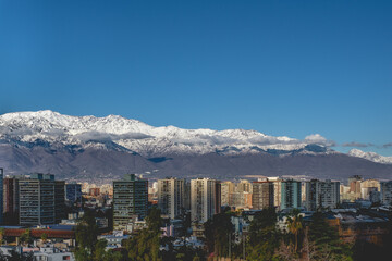 Panoramic view of lonely clouds in the sky over Santiago skyline and the snowed Los Andes mountains, Chile
