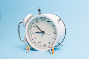 Alarm clock worker on blue background