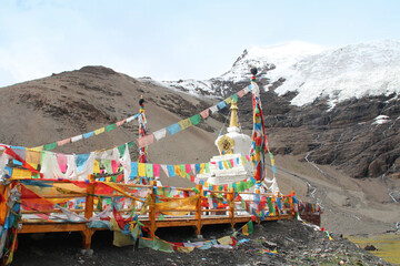 View of the Karola glacier near the highway with the Tibetan prayer flags and stupa, Tibet, China