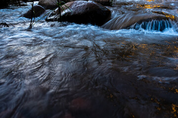 Stream of flowing river water abstract blurred motion the evening light at Sapun village, Boklua, Nan Province, Thailand