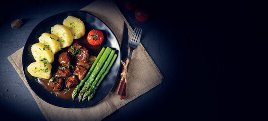 dumplings with beef goulash and green asparagus