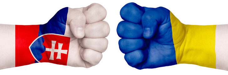 Two hands are clenched into fists and are located opposite each other. Hands painted in the colors of the flags of the countries. Slovakia vs Ukraine