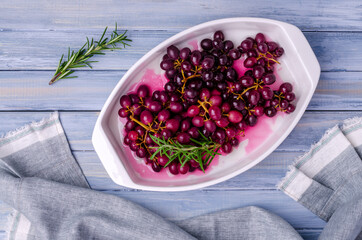Baked bunches of dark grapes with rosemary