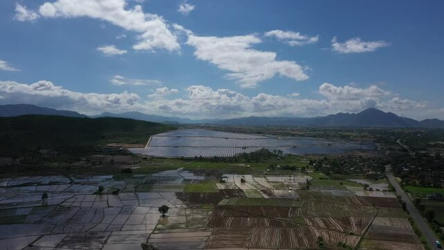 Solar panel produces green, environmentaly friendly energy from the setting sun. View from drone. Landscape picture of a solar plant that is located inside a valley, Krong Pa, Gia Lai, Vietnam