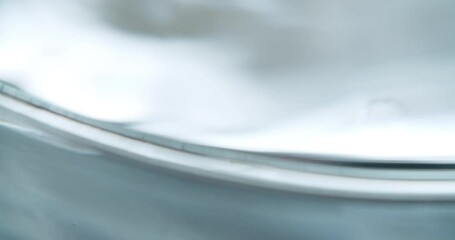 Abstract macro art shot of a petri dish filled with water. Water forming mesmerizing noise and patterns. Petri dish getting moved at the end of the shot. - Powered by Adobe