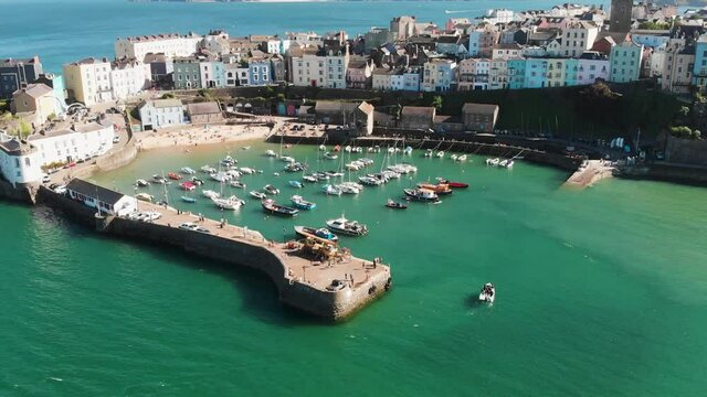 Slow Panning Revealing Aerial Drone Shot of The Harbour in The Historical Welsh Holiday Town of Tenby in Wales. Showing Boats Coming in And Out, With The Medieval Fort in the Background.