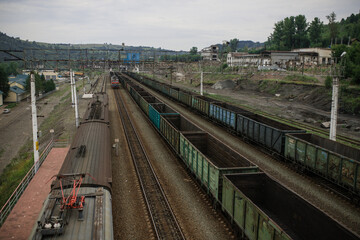 Obraz premium Top view of a railway marshalling yard with railroad cars. Coal industry. Commodity train with coal. Coal wagons, coal transportation in freight wagons. Formation of a coal train in a freight depot. 