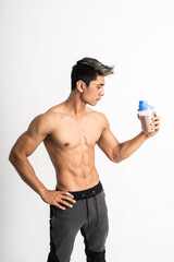 Fototapeta premium man with muscular body holding a bottle with one hand on waist stand facing side on isolated background